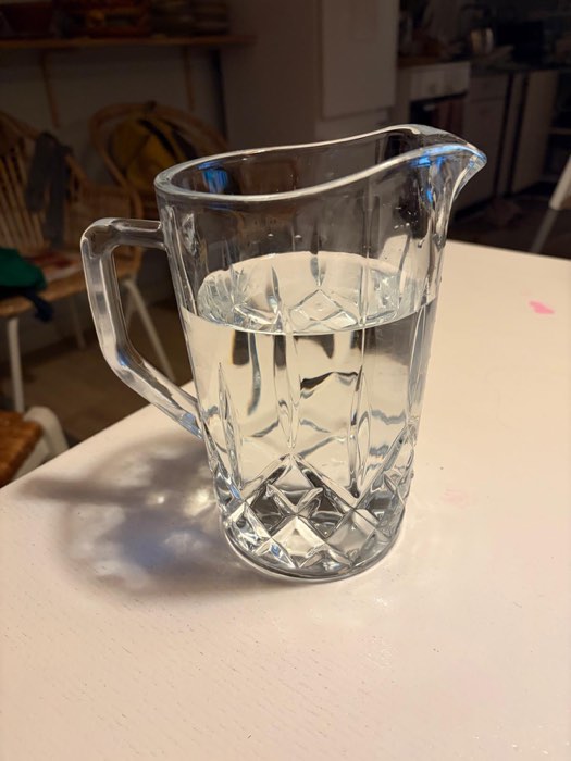 Eine Glaskanne mit Wasser auf einem hellen Tisch