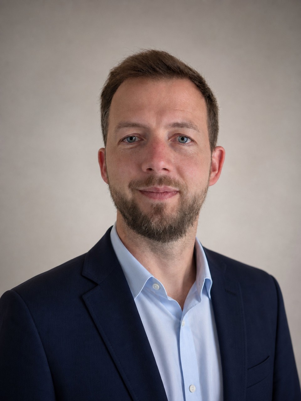 Professionelles Studio-Bewerbungsfoto von Philipp im dunklen Sakko vor neutralem Hintergrund