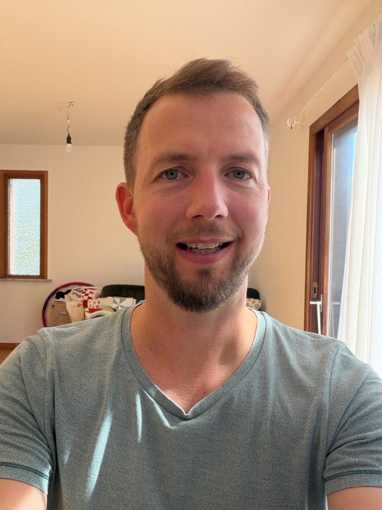 Selfie von Philipp im grauen T-Shirt in einem Wohnraum